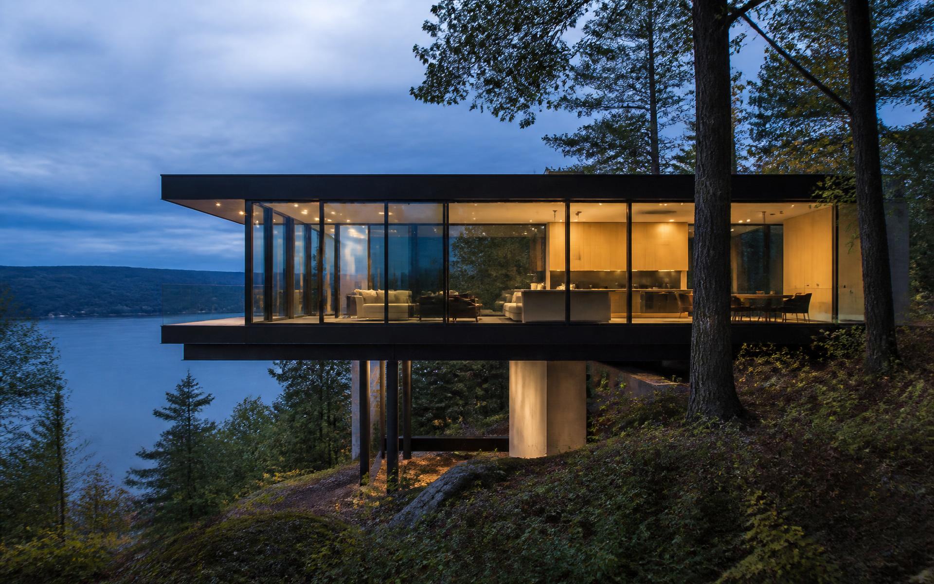 Contemporary lake house sited on a wooded slope above the water
