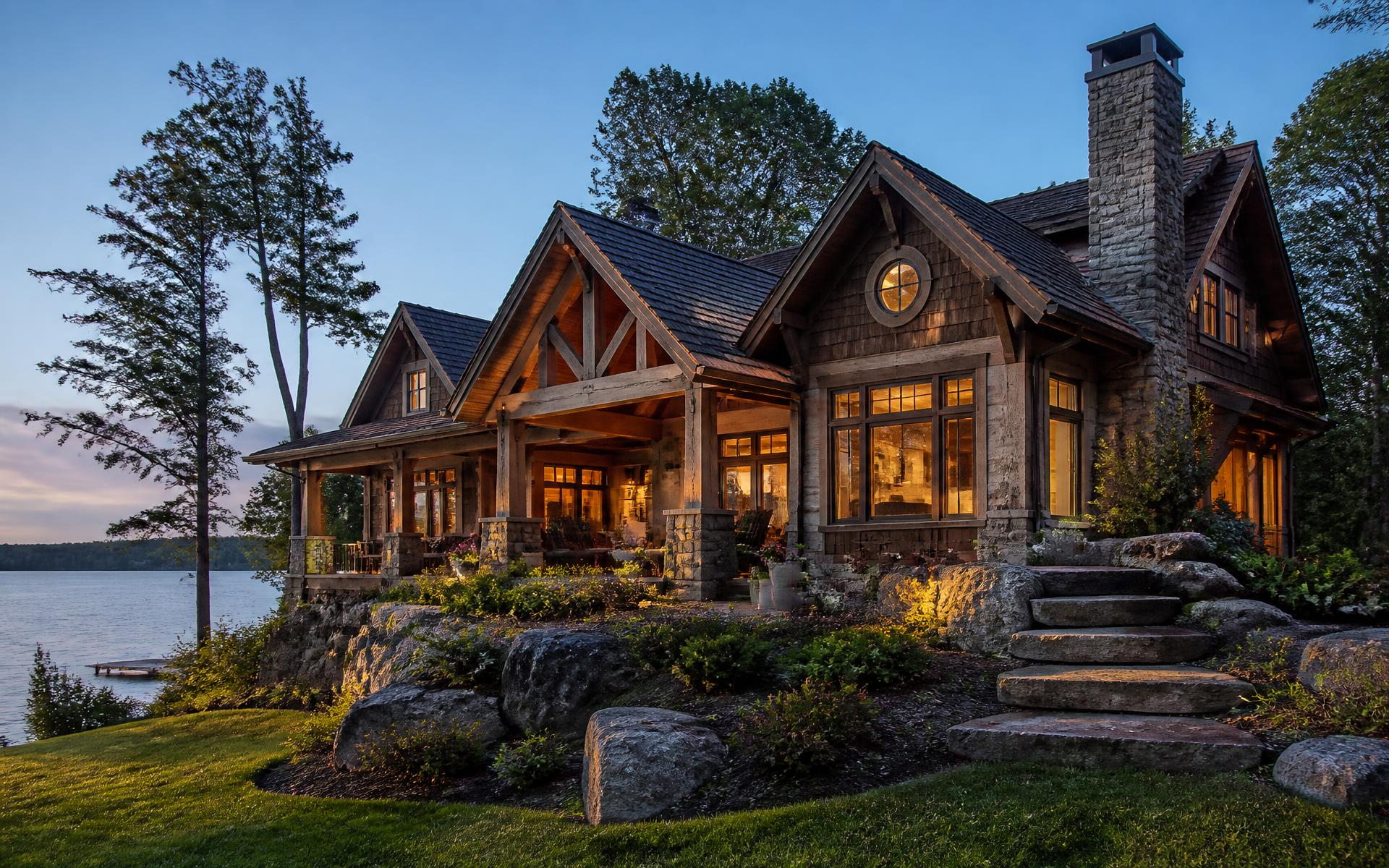 Custom waterfront home at dusk with terraced stone walls