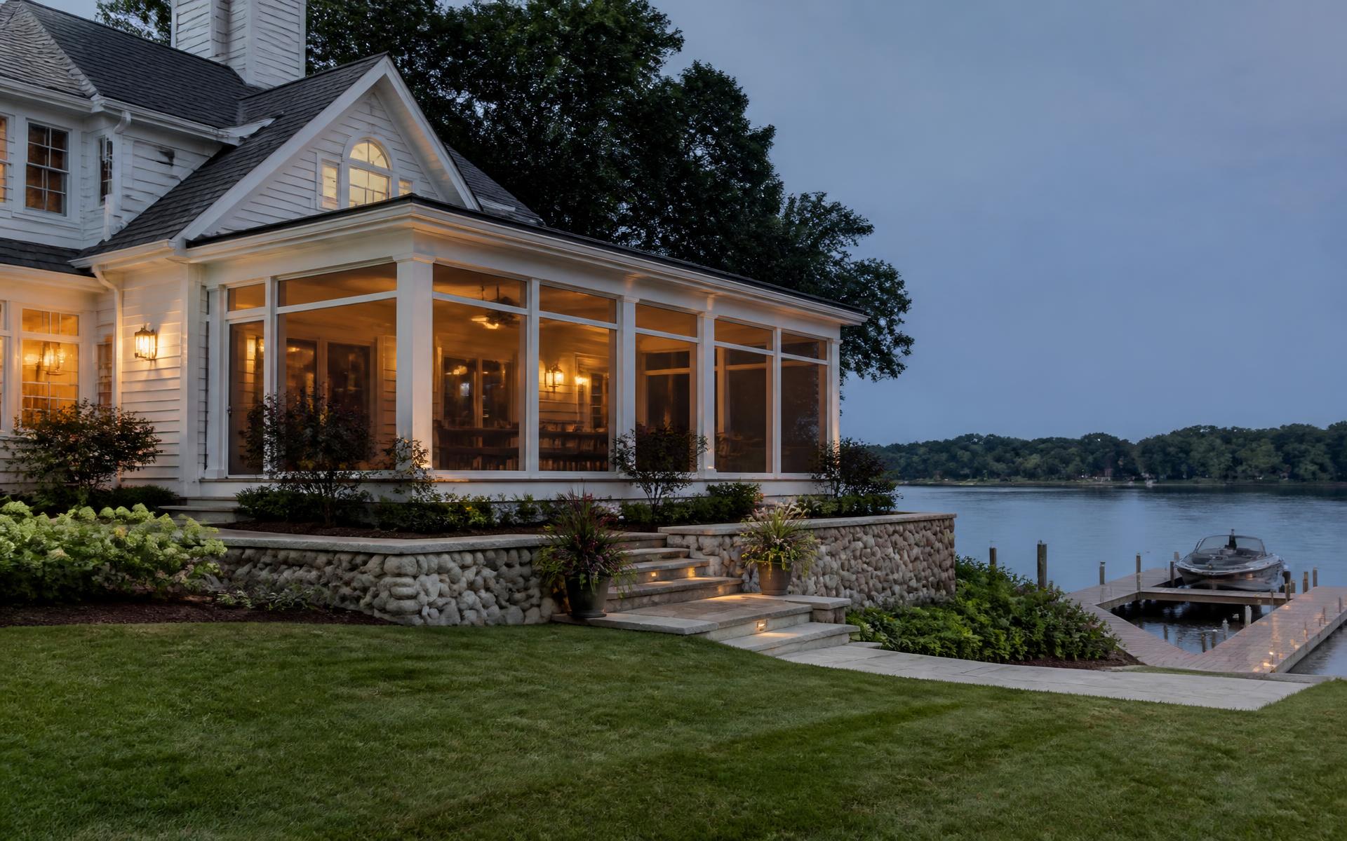 Contemporary waterfront estate at dusk on Mountain Island Lake with lit terrace and private dock