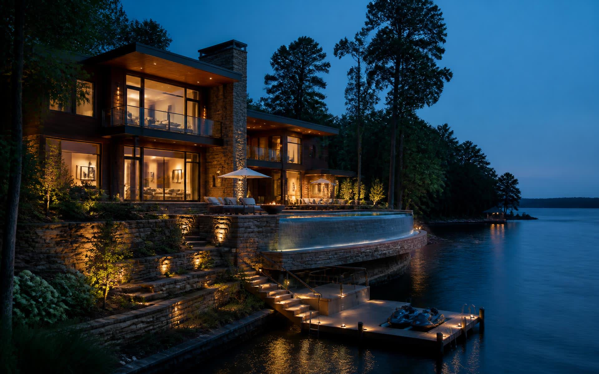 Waterfront estate with terraced stone walls and a lit private dock on Mountain Island Lake